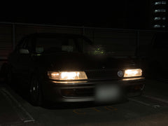 An older car at night with the warm white LED headlight bulbs fitted